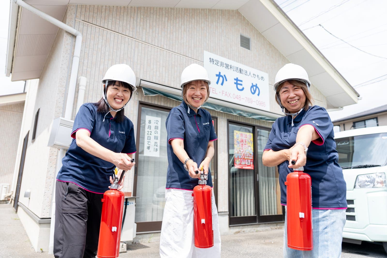 事業所の前で消火器を構えて防災訓練をする職員